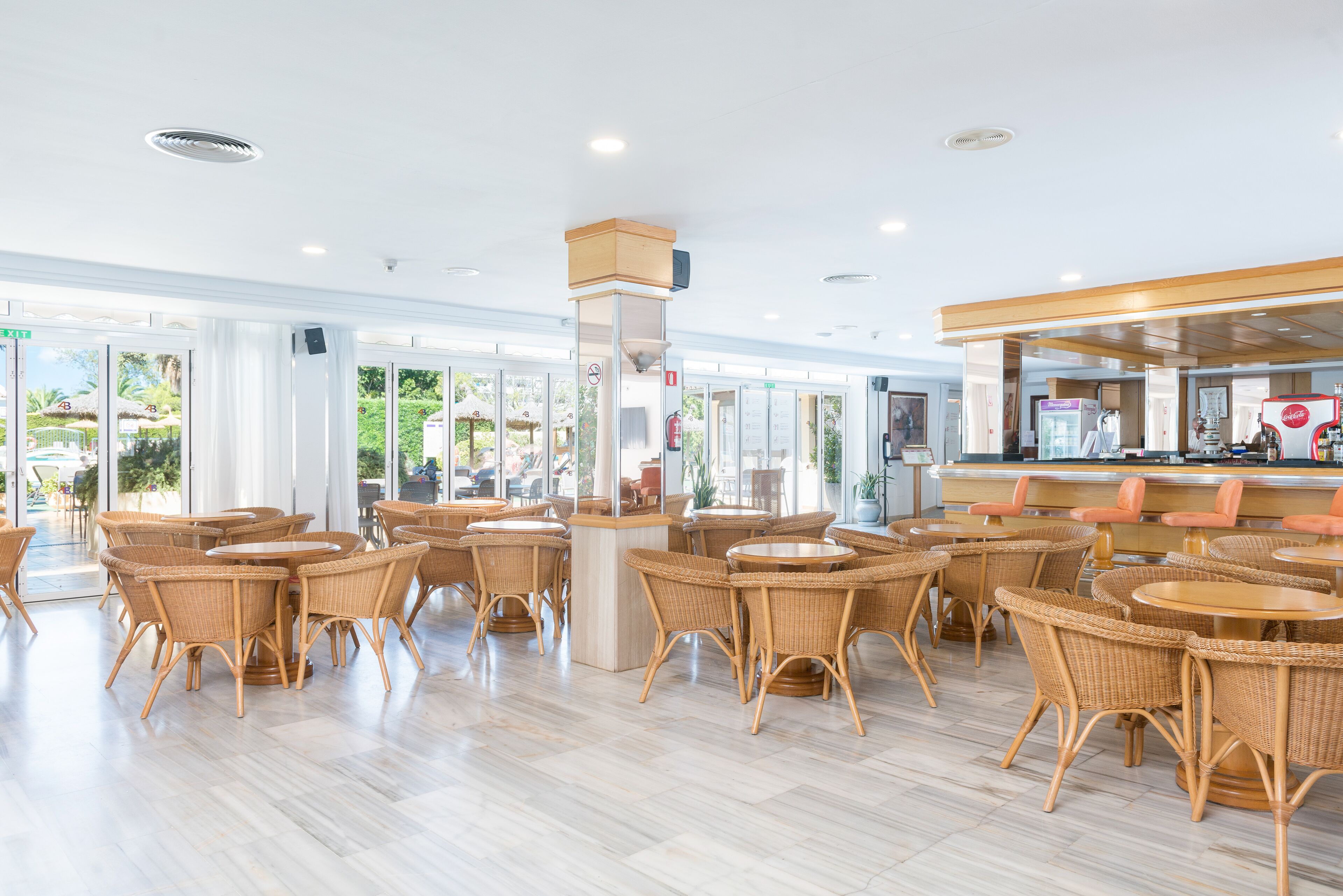 A spacious indoor area with wicker furniture and a bar area.