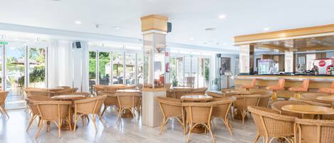 A spacious indoor area with wicker furniture and a bar area.