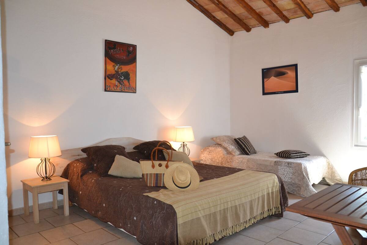 Un dormitorio con dos camas, una mesa de madera y una mesita de noche con lámparas.