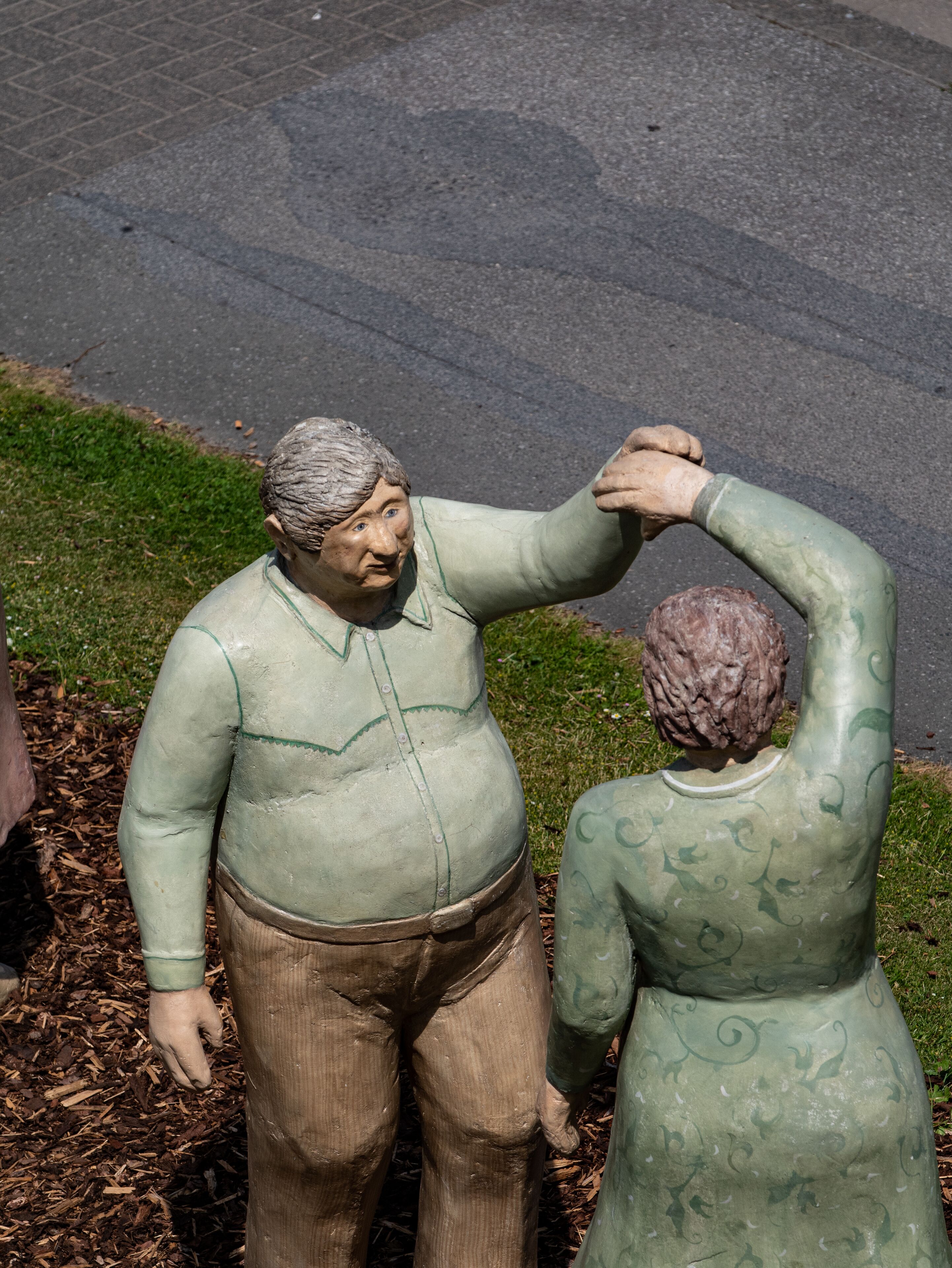 Une sculpture représentant un homme et une femme dans un parc.
