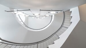 A spiral staircase with a modern design, featuring a curved railing and a series of lights along the handrail. - Hotel Sonne Rheda Wiedenbrück (Rheda-Wiedenbruck)