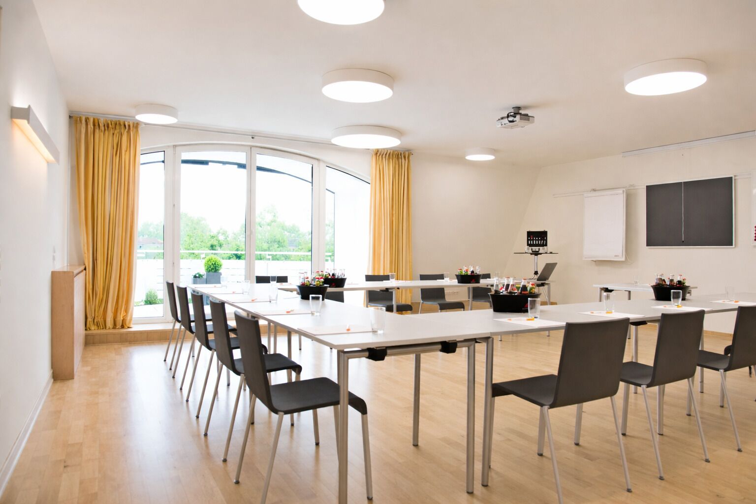 A conference room with a long table, chairs, a projector, and a whiteboard.