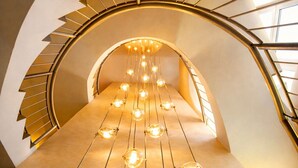 A spiral staircase with a modern design, featuring a series of hanging light bulbs along the steps. - Hotel Sonne Rheda Wiedenbrück (Rheda-Wiedenbruck)