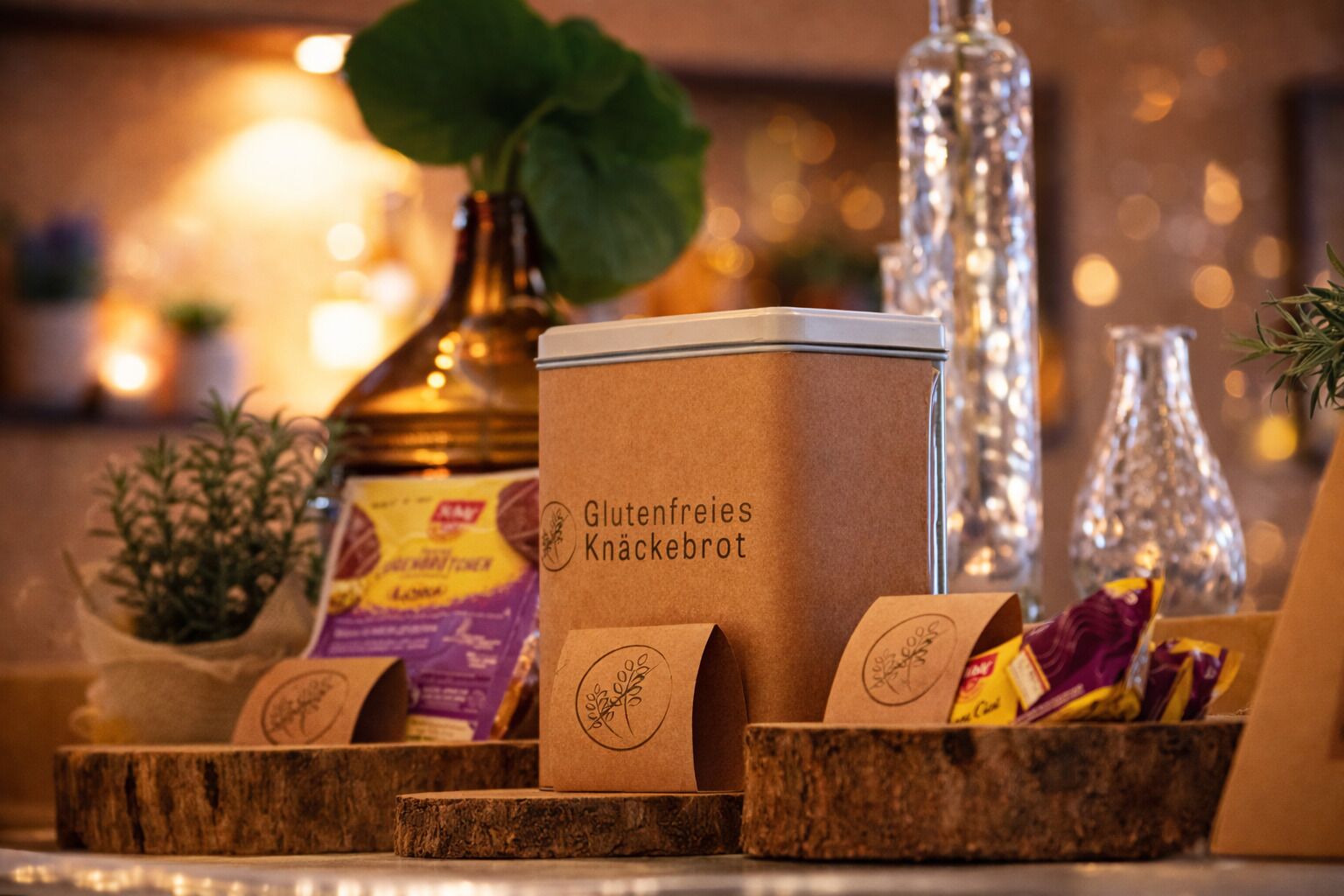 Gluten-free cookies in a wooden box with a label, surrounded by small potted plants and decorative bottles.