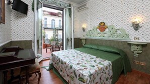 A bedroom with a bed, a desk, and a chair. There is a window with a view of buildings outside. - Residenza Horti Luculliani (Rome)