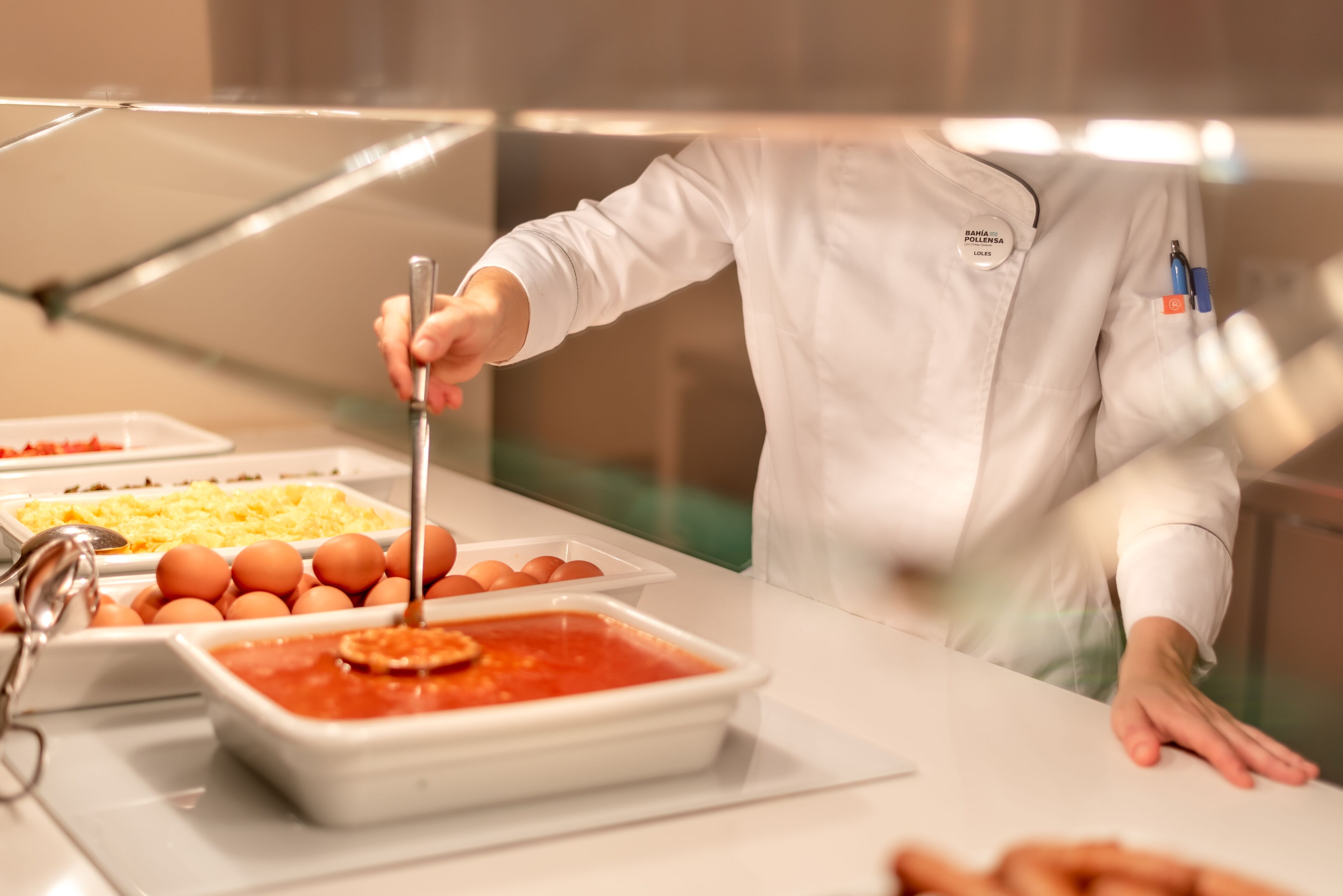 Un buffet con diversi cibi, tra cui uova, formaggio e un piatto a base di pomodoro.