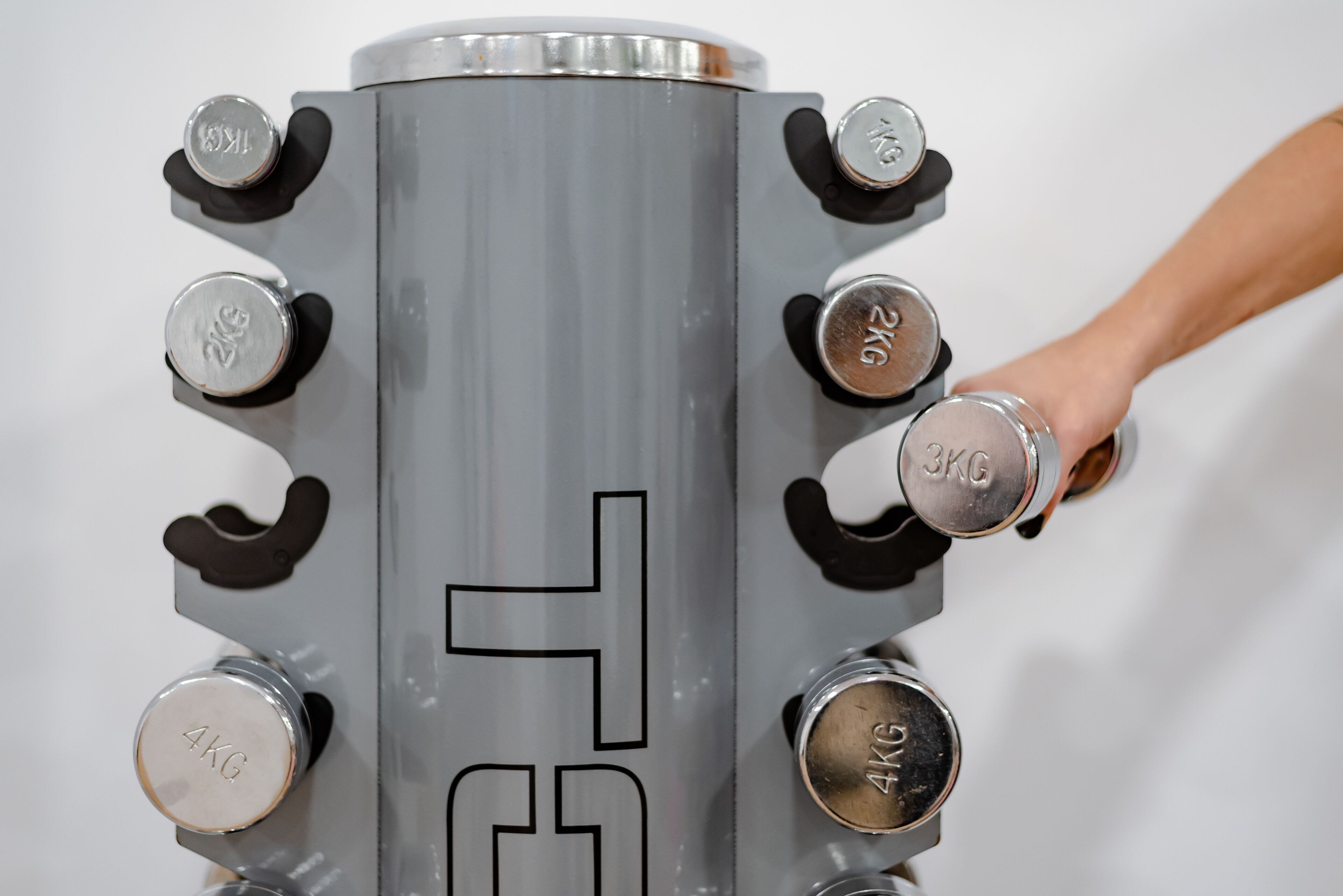 A metallic cylindrical object with multiple weight markings, including 2KG, 3KG, and 4KG.