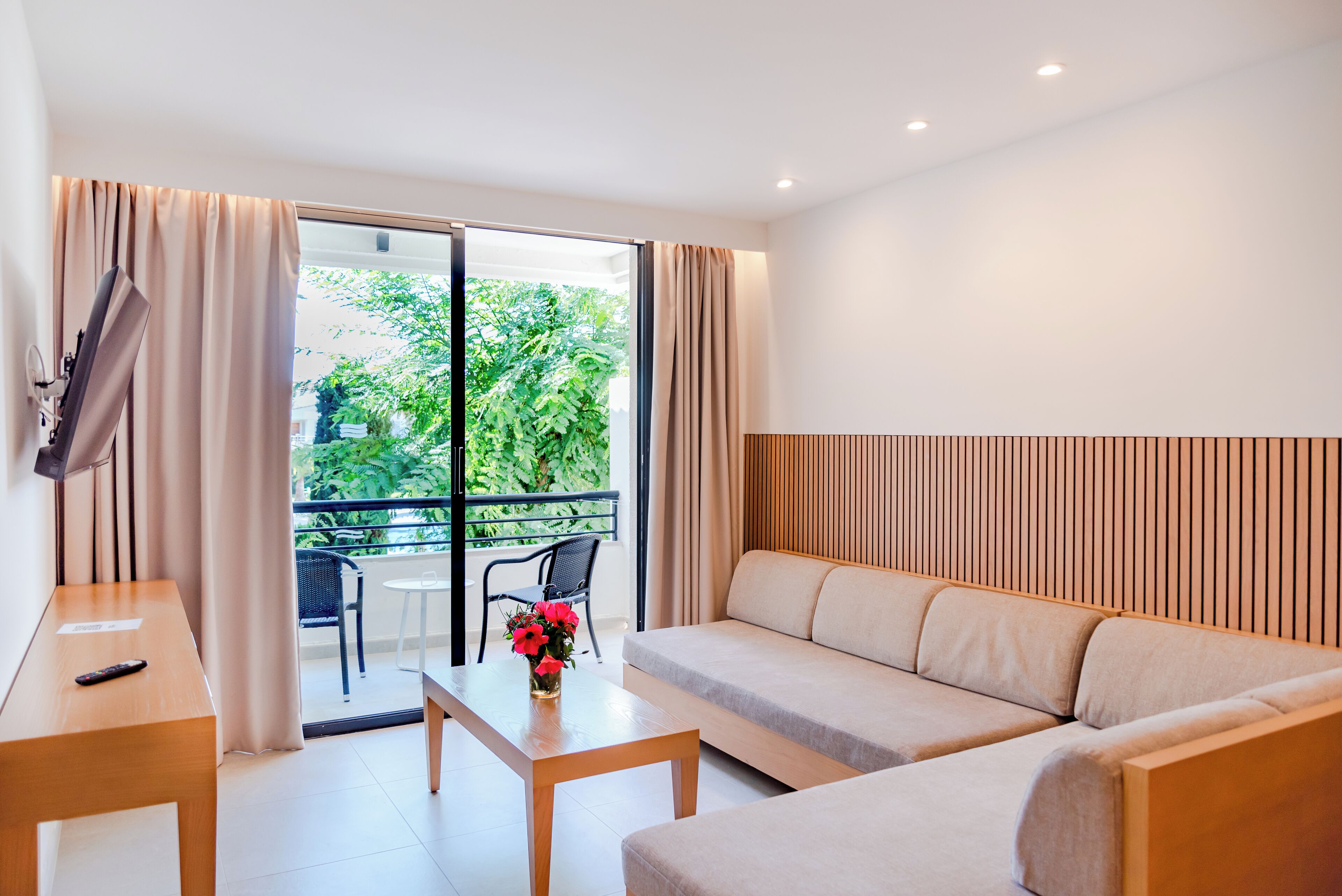 Una sala de estar moderna con un sofá, una mesa de centro y un televisor sobre un mueble.