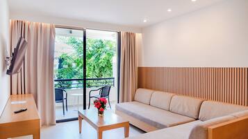 Una sala de estar moderna con un sofá, una mesa de centro y un televisor sobre un mueble.