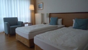 A hotel room with two beds, a chair, a lamp, and a picture on the wall. - Hotel Thiesmann (Muelheim an der Ruhr)