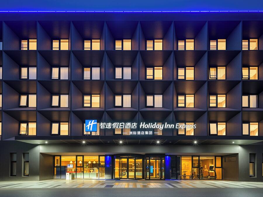 A Holiday Inn Express hotel with a modern facade, multiple balconies, and a well-lit entrance.