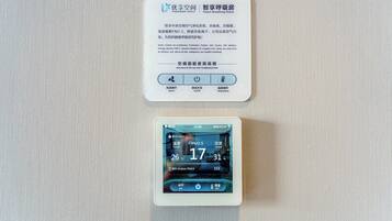 Un monitor digital de calidad del aire que muestra la temperatura y los niveles de humedad interiores.