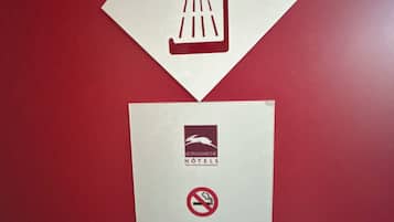 Um sinal com um ícone de chuveiro e texto em alemão, indicando comodidades e políticas do hotel.