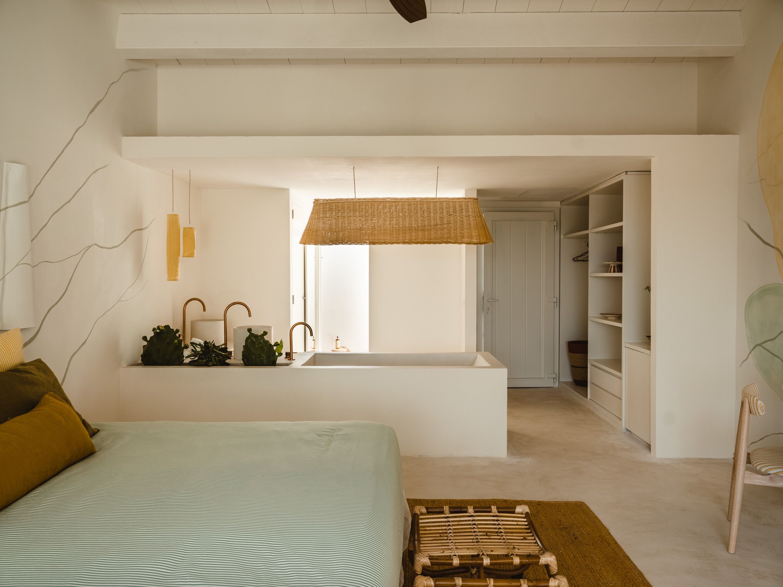 Un dormitorio moderno con una cama grande, un lavamanos integrado y una lámpara de techo de mimbre.
