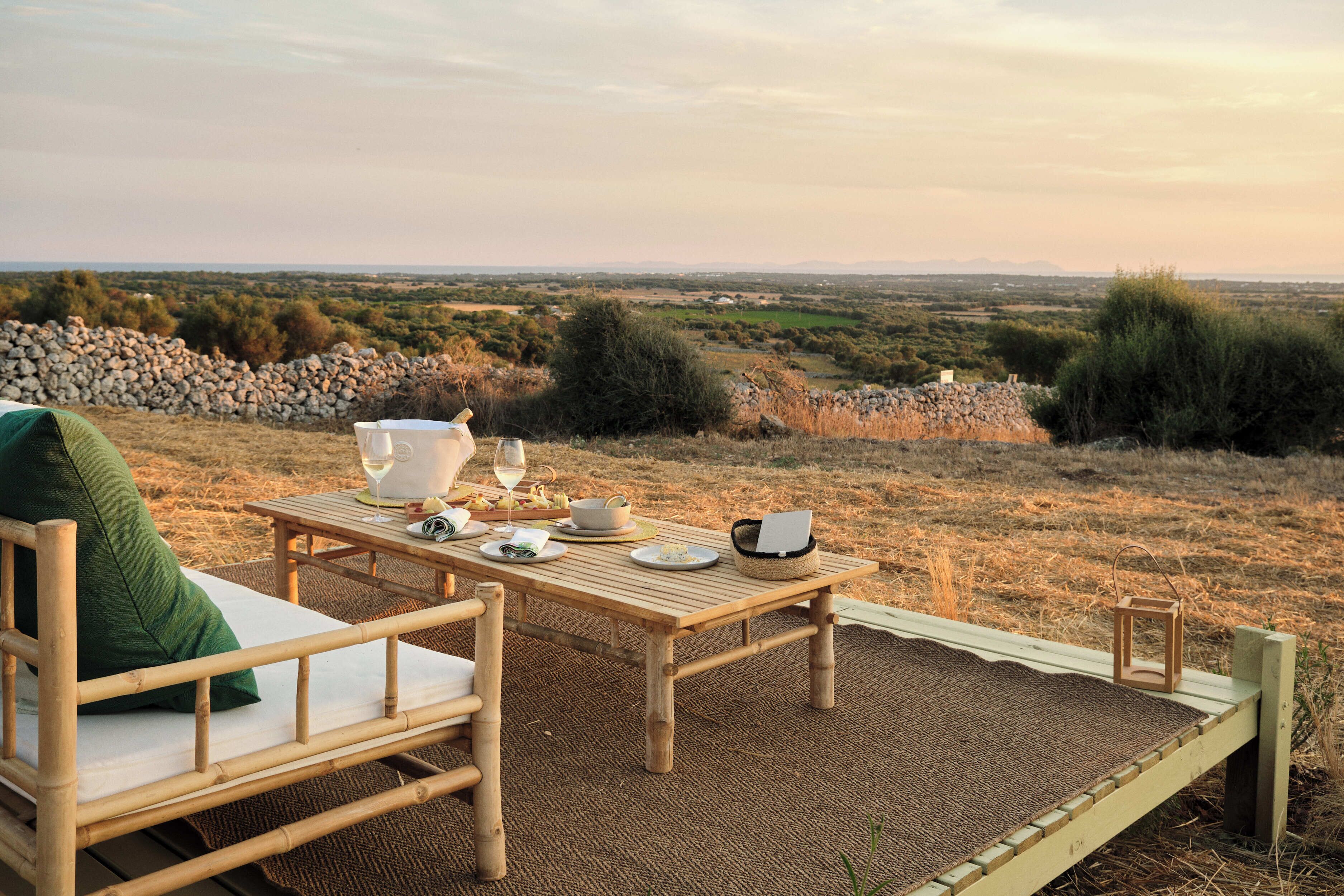 Een houten terras met een gedekte tafel, met uitzicht op een schilderachtig landschap.