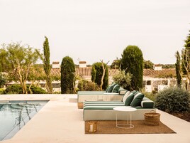 Una piscina al aire libre de temporada, sombrillas