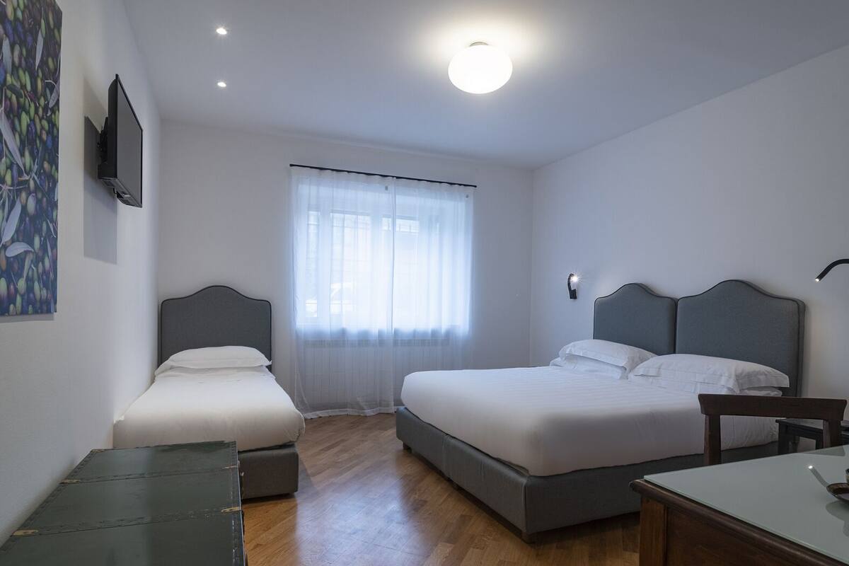 A bedroom with two single beds, a desk, and a chair.