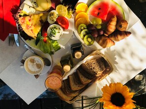 A breakfast spread with various fruits, pastries, and beverages on a table. - Home ApartHotel (Kraków)