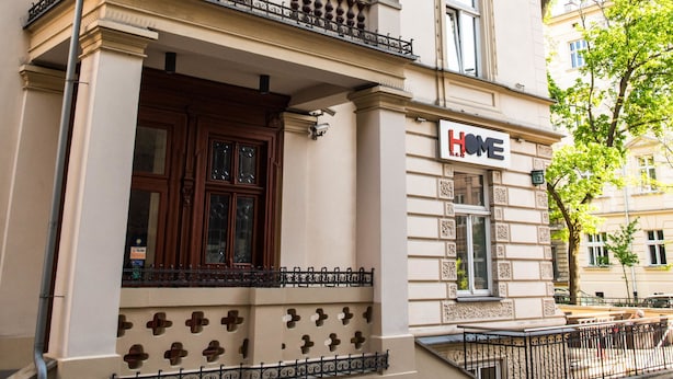 A building with a 'HOME' sign, ornate architectural details, and a balcony. - Home ApartHotel (Kraków)