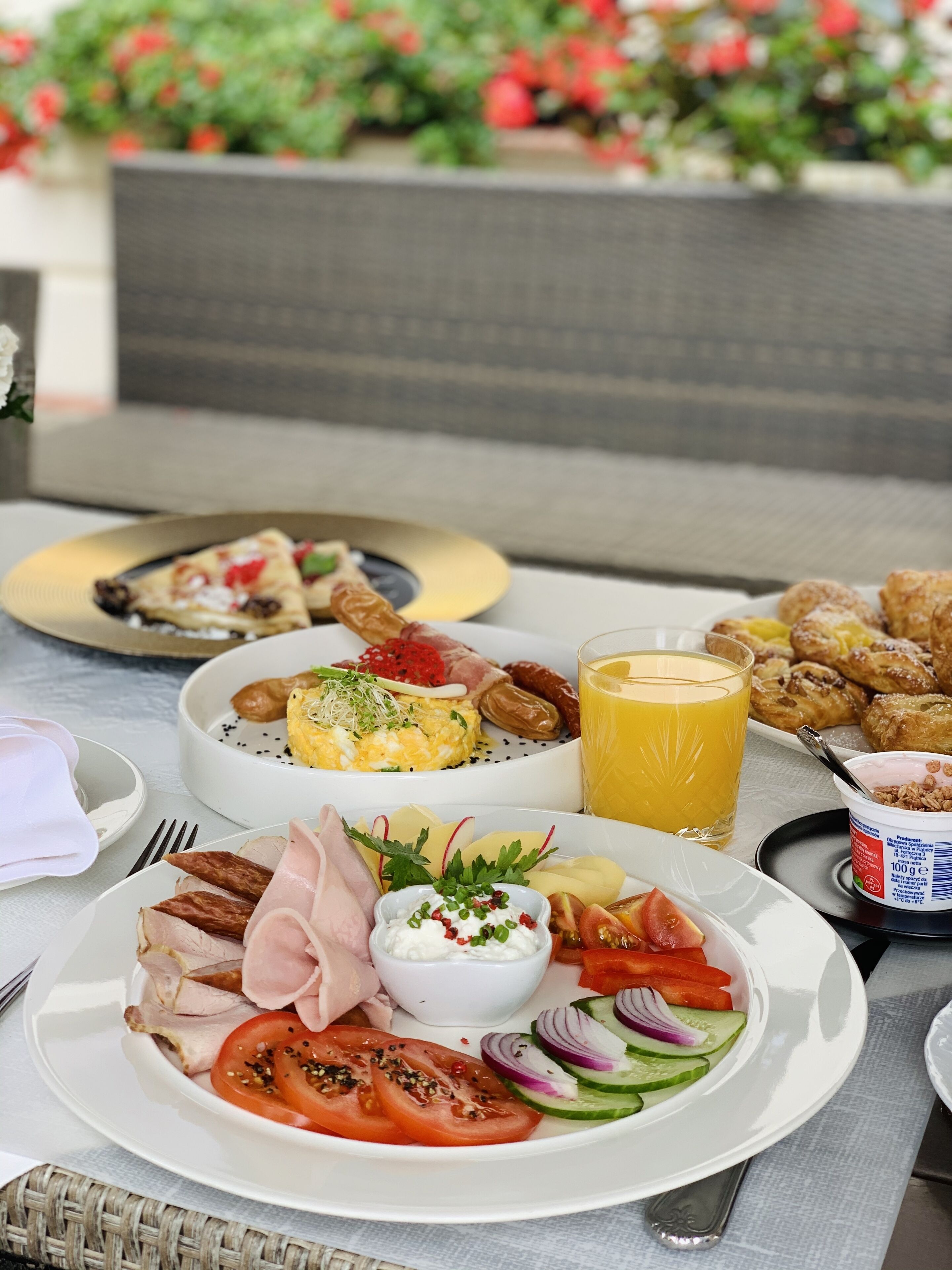 A breakfast buffet with various dishes including eggs, meats, and fresh vegetables.