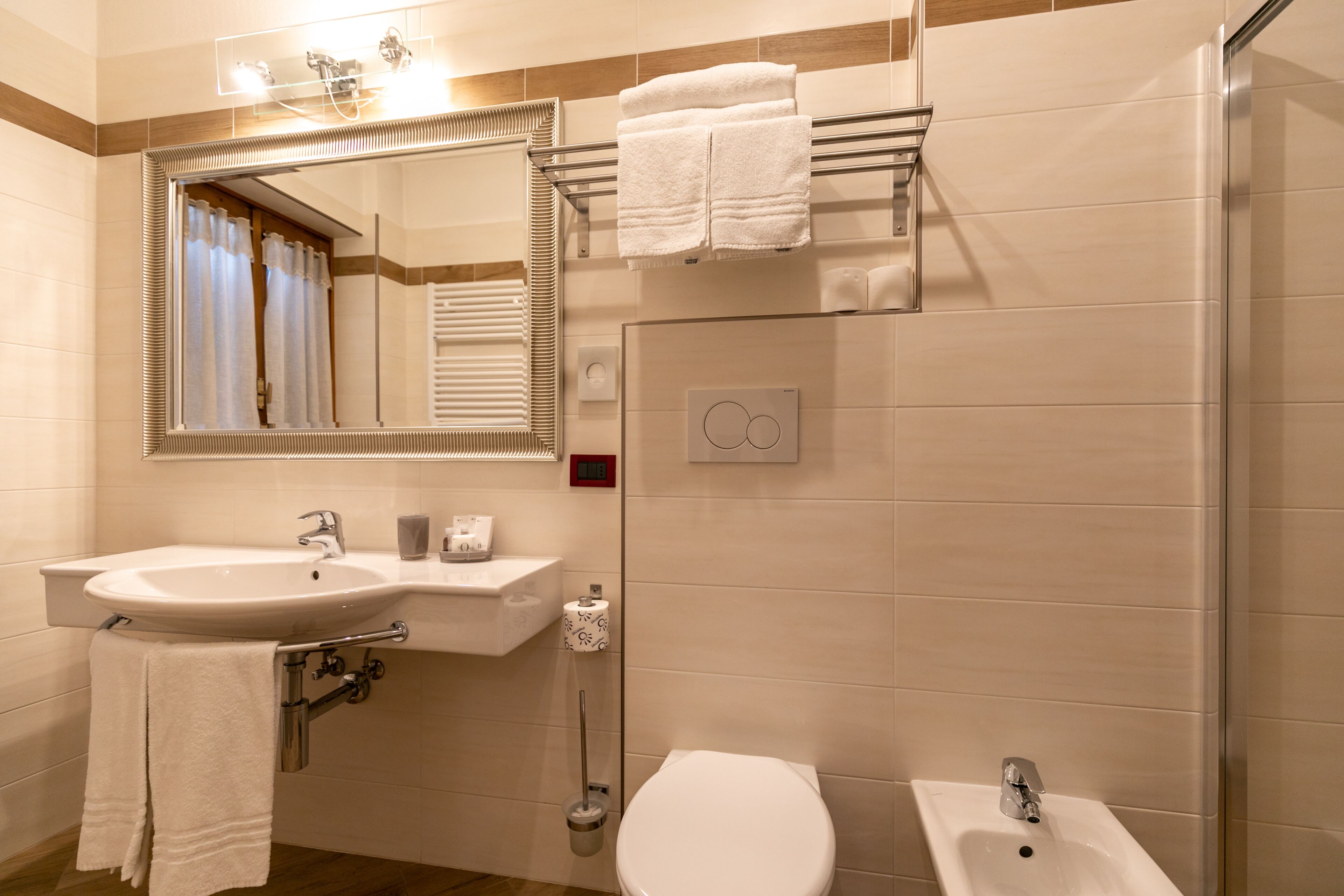 A modern bathroom with a sink, mirror, and toilet.