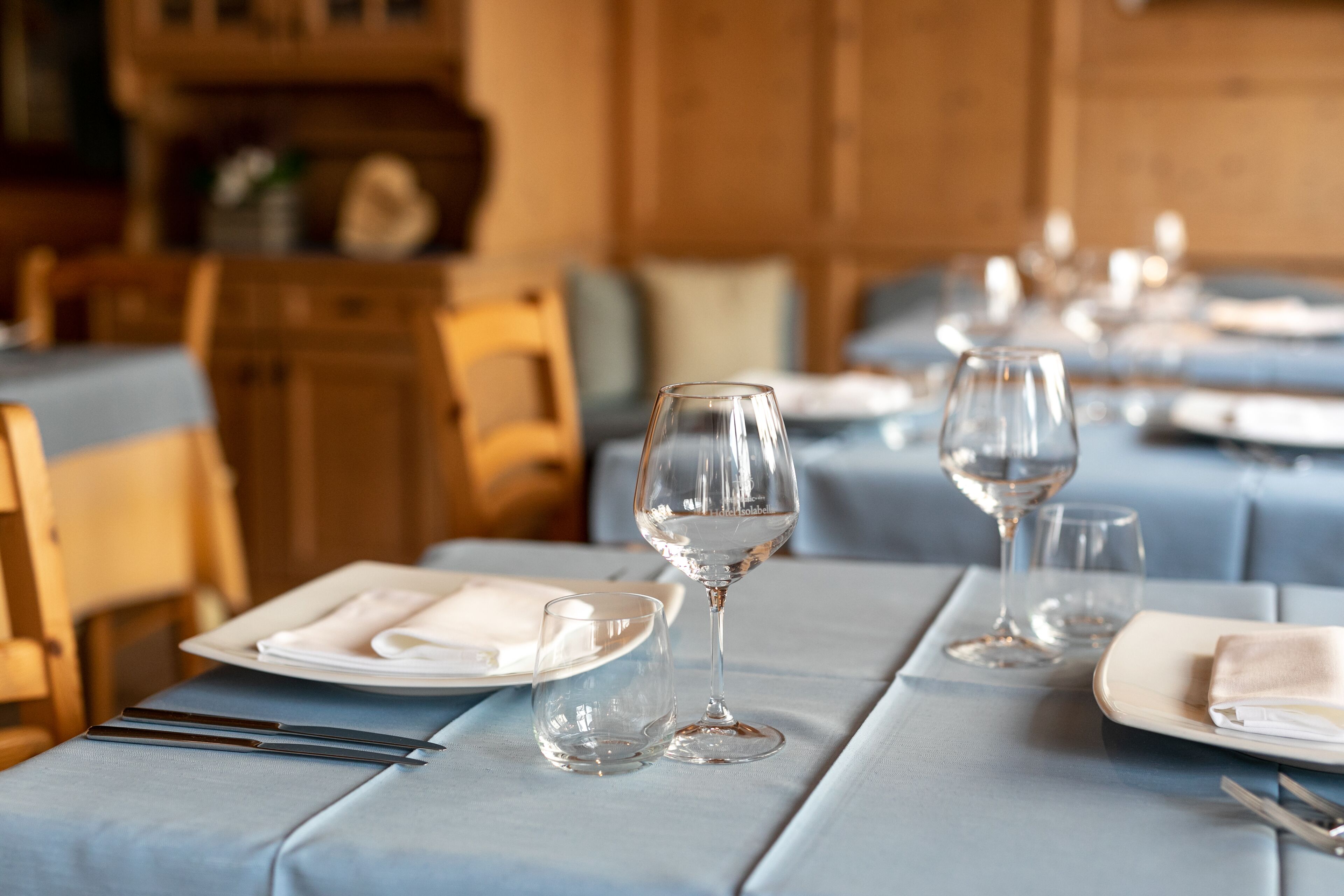 A dining table set with plates, glasses, and cutlery.
