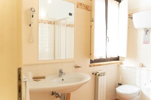 A bathroom with a sink, mirror, shower, and toilet. - Hotel Ristorante Vecchia Vibo (Vibo Valentia)