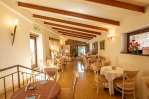 A hotel dining area with multiple tables and chairs, a staircase, and a view of the outdoors. - Hotel Ristorante Vecchia Vibo (Vibo Valentia)