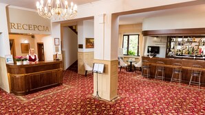A hotel reception area with a reception desk, a bar, and seating arrangements. - Arkadia (Warsaw)