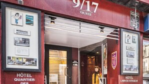 A hotel entrance with a sign reading "9/17 OUEST" and "HOTEL L'ABRI DU VOYAGEUR".