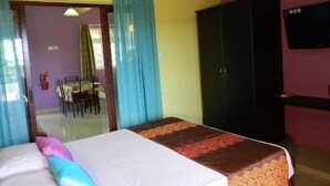A bedroom with a bed, a wardrobe, and a television. - VillaOSoleil Apartments (Grand-Baie)