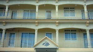A multi-story hotel with balconies and a central entrance. - VillaOSoleil Apartments (Grand-Baie)