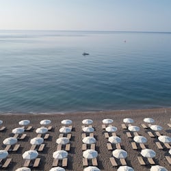 Vlak bij het strand, ligstoelen, parasols, strandlakens