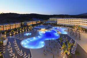 Una piscina techada, una piscina al aire libre, sombrillas
