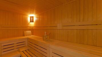 A sauna with wooden benches and a wall-mounted light fixture.