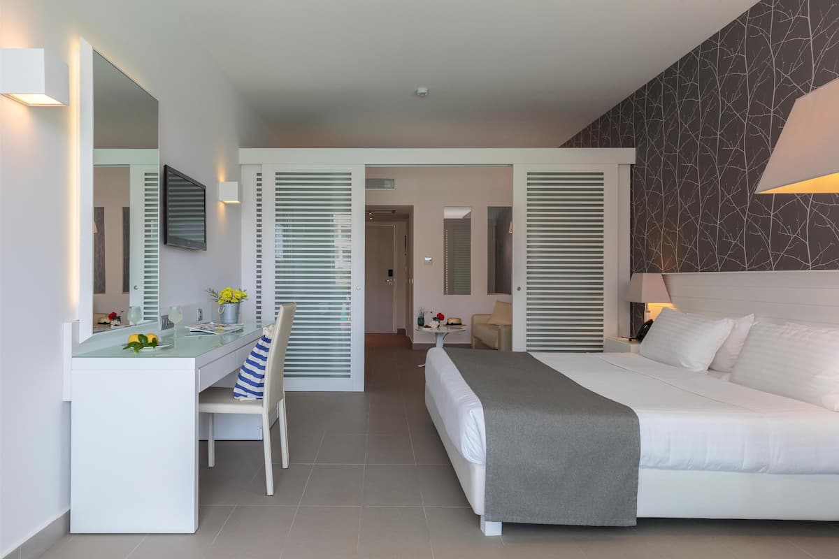 Quarto de hotel moderno com cama, escrivaninha e cadeira.