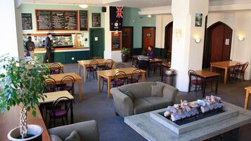 A restaurant with multiple seating areas, including tables and chairs, and a bar counter.