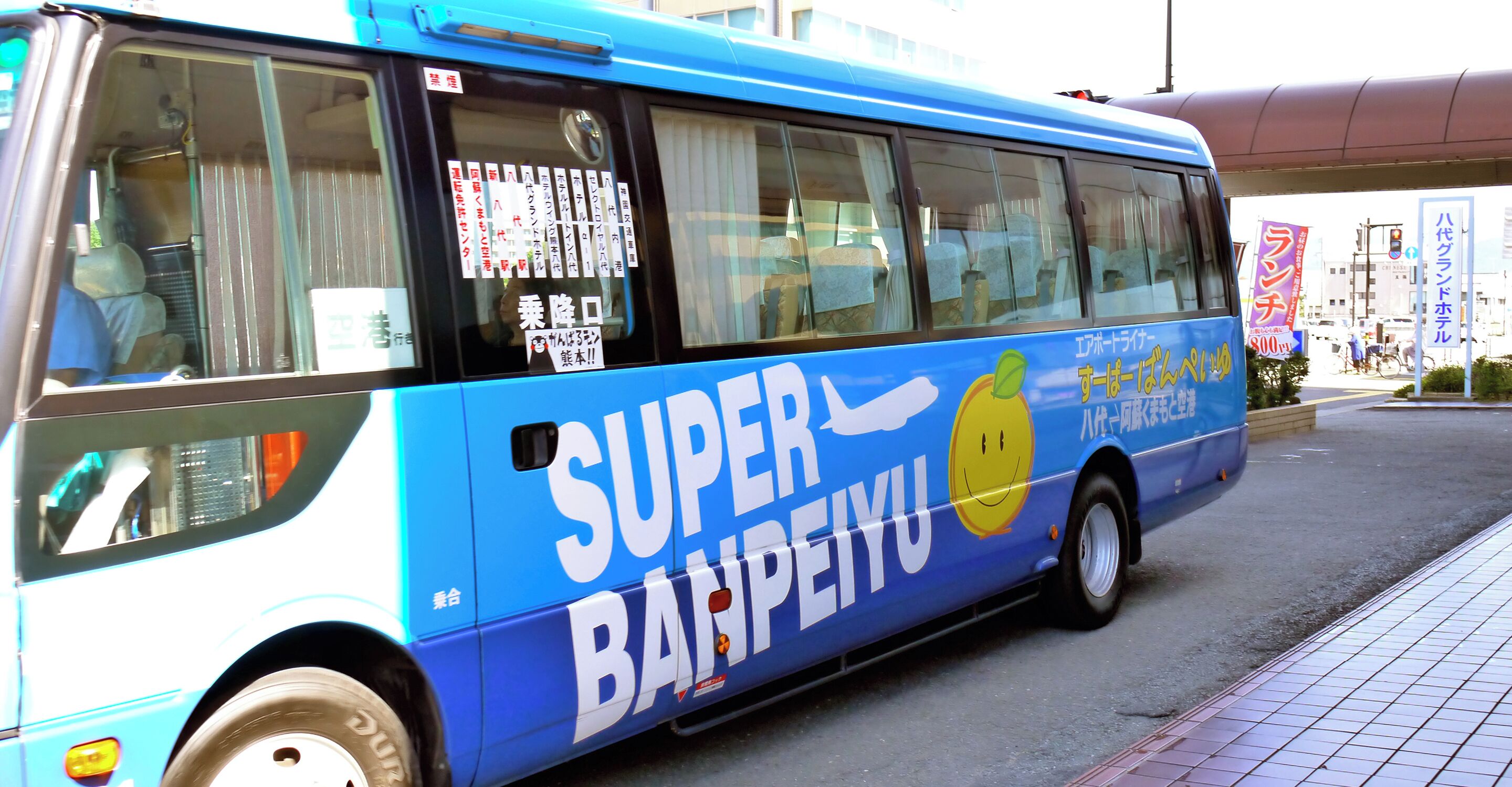A bus with 'SUPER BANPEIYU' branding, large windows, and a visible advertisement on the side.