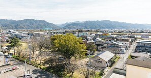 A residential area with houses, a parking lot, and mountains in the background.