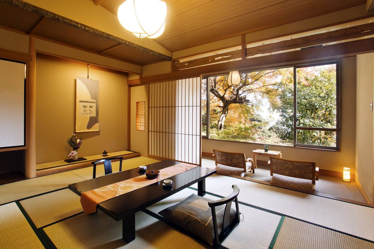 Une pièce de style japonais traditionnel, avec un sol recouvert de tatamis, une table basse et des portes coulissantes.