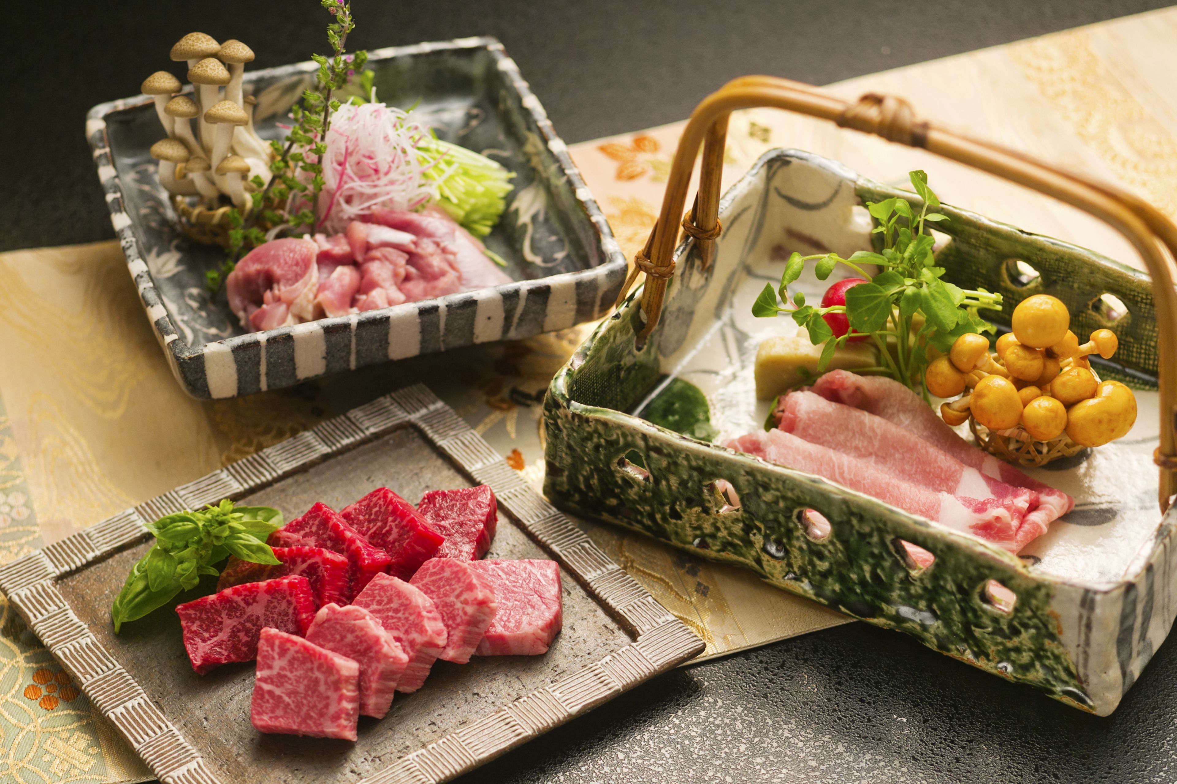 A variety of food items including sliced meat, mushrooms, and vegetables on a table.