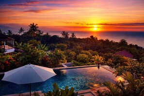 A resort with a swimming pool, palm trees, and a sunset view. - The Hamsa Bali Resort (Banjar)
