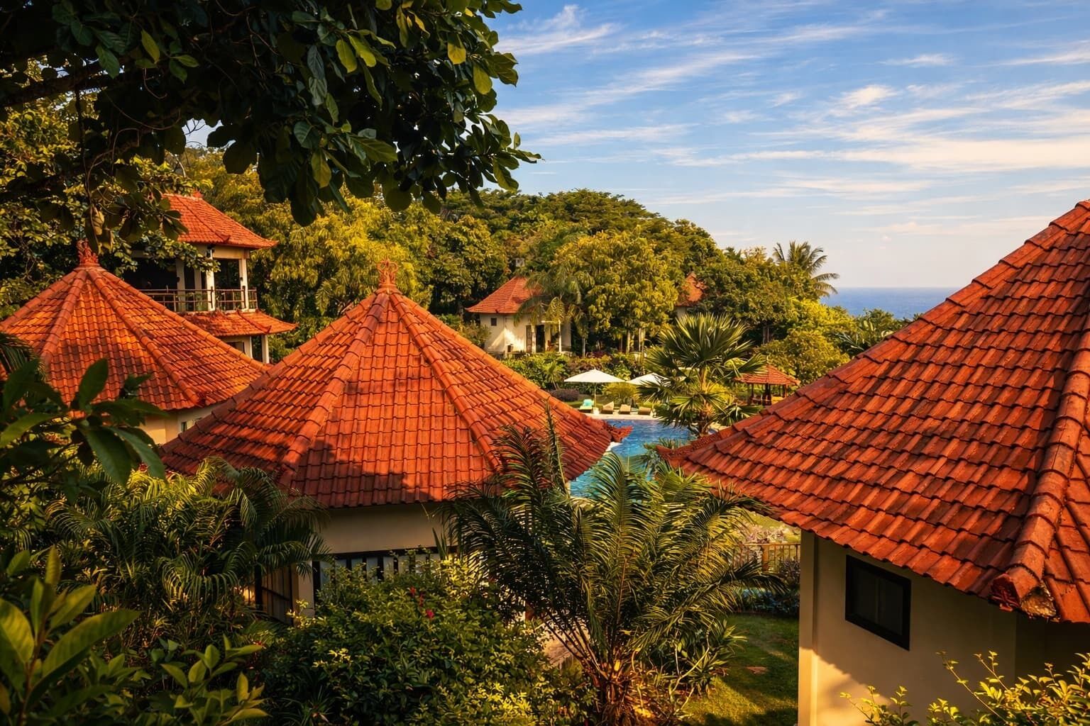 Een resort met meerdere gebouwen, een zwembad en weelderige begroeiing.