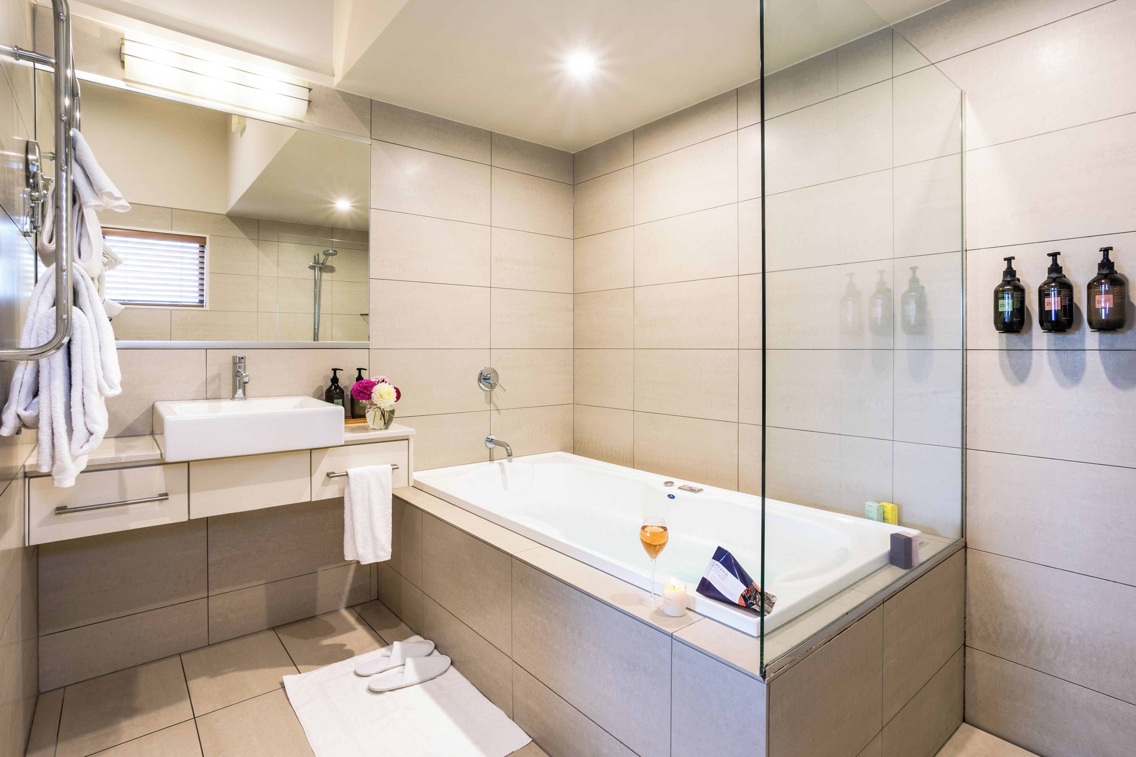 Un bagno moderno con una vasca da bagno ampia, un mobile doppio lavabo e un box doccia in vetro.