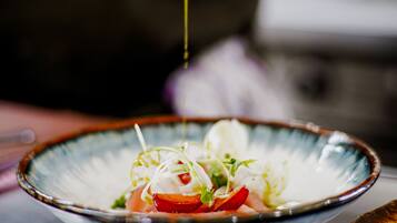 A bowl of food with a sauce being poured over it.