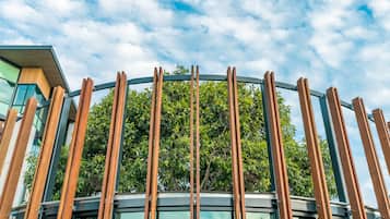 Un edificio moderno con fachada de vidrio curvo y listones verticales de madera.