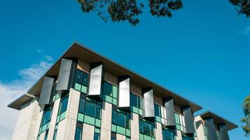 A modern building with a flat roof, large windows, and a symmetrical facade.