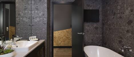 Un baño moderno con dos lavamanos, una bañera grande y un revestimiento de pared de madera.