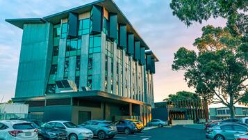 A modern building with a parking lot and several cars.
