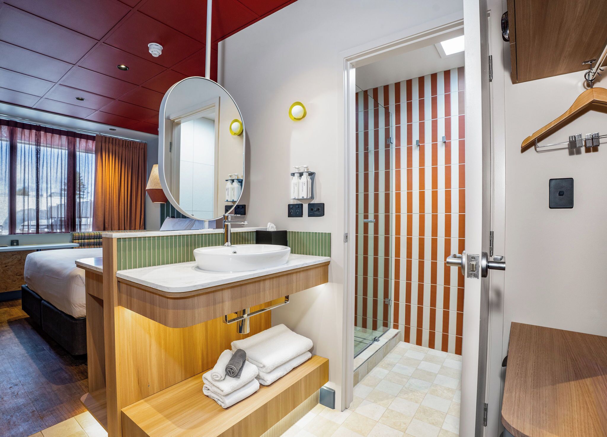 A modern bathroom with a sink, mirror, and shower.